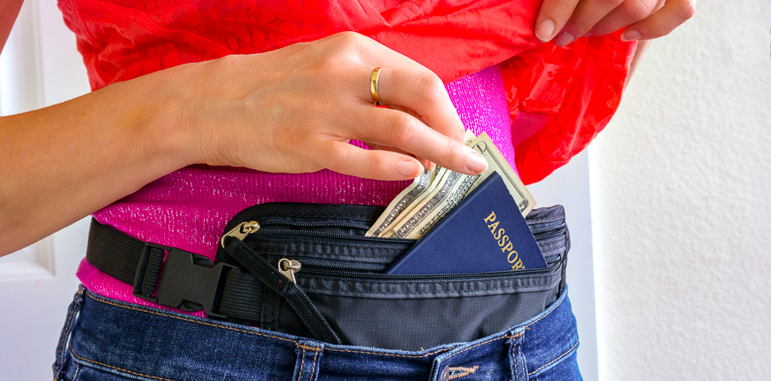 10 Smart Ways To Carry Money While Traveling Smartertravel - woman getting cash and passport from hidden travel money belt she has under her clothes to