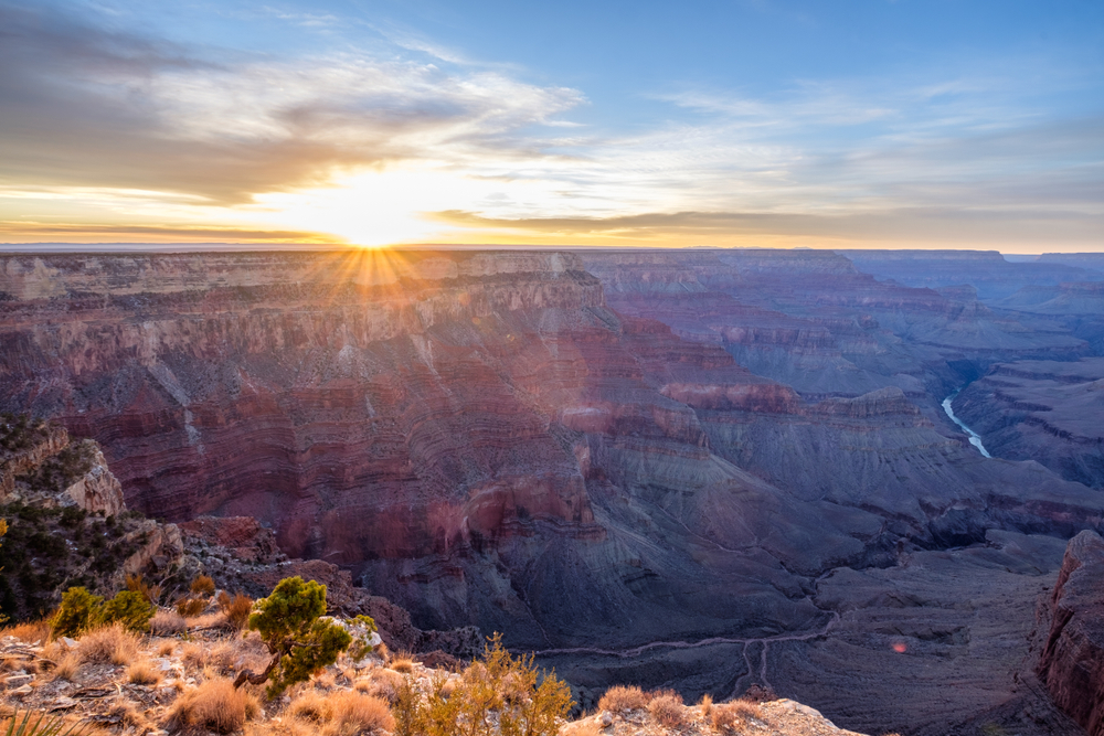 Sun peeking above the rim of grand canyon