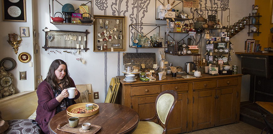 woman with mug at random tearoom and curiosity shop.