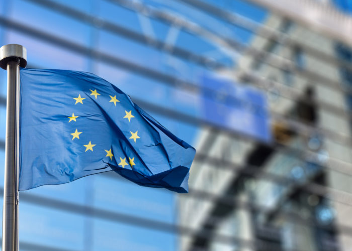 European Union flag flying in front of the European Union Parliament building