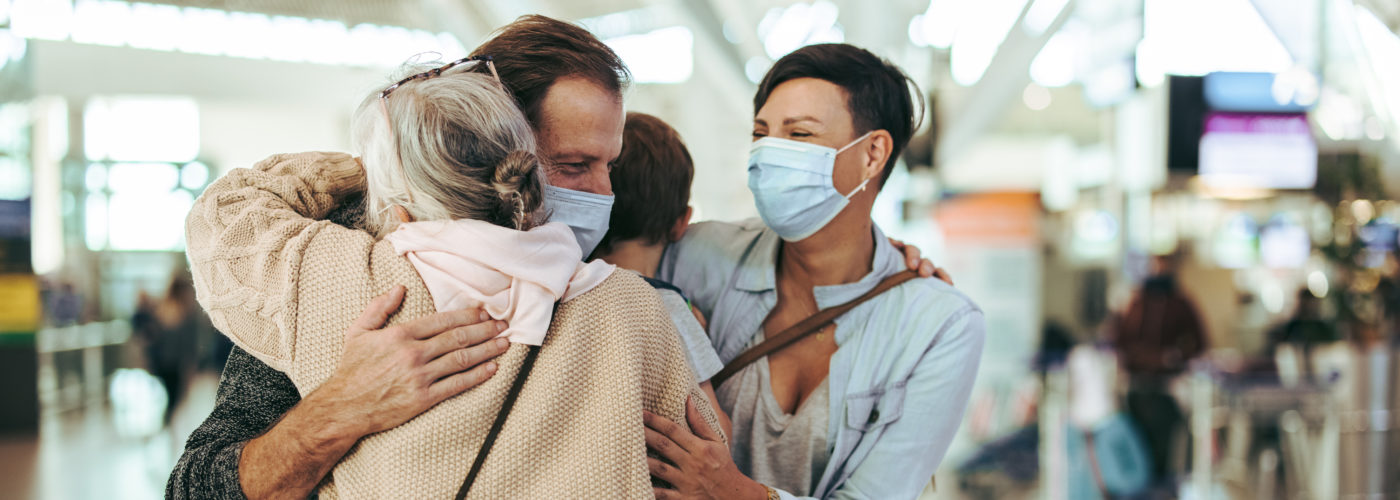 Elderly person greeting family at airport