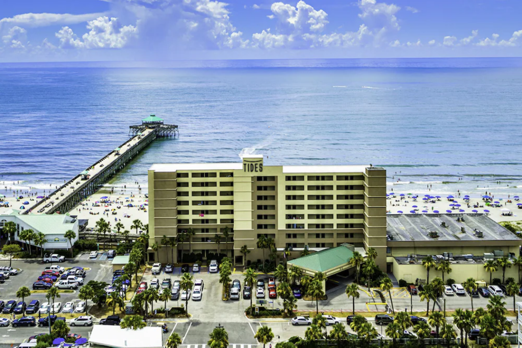 Aerial view of the Tides Folly Beach Hotel, pier to the left and endless ocean in the background