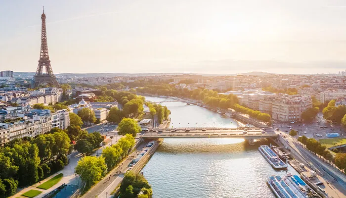 Paris aerial panorama with river Seine and Eiffel tower, France. Romantic summer holidays vacation destination. Panoramic view above historical Parisian buildings and landmarks with blue sky and sun