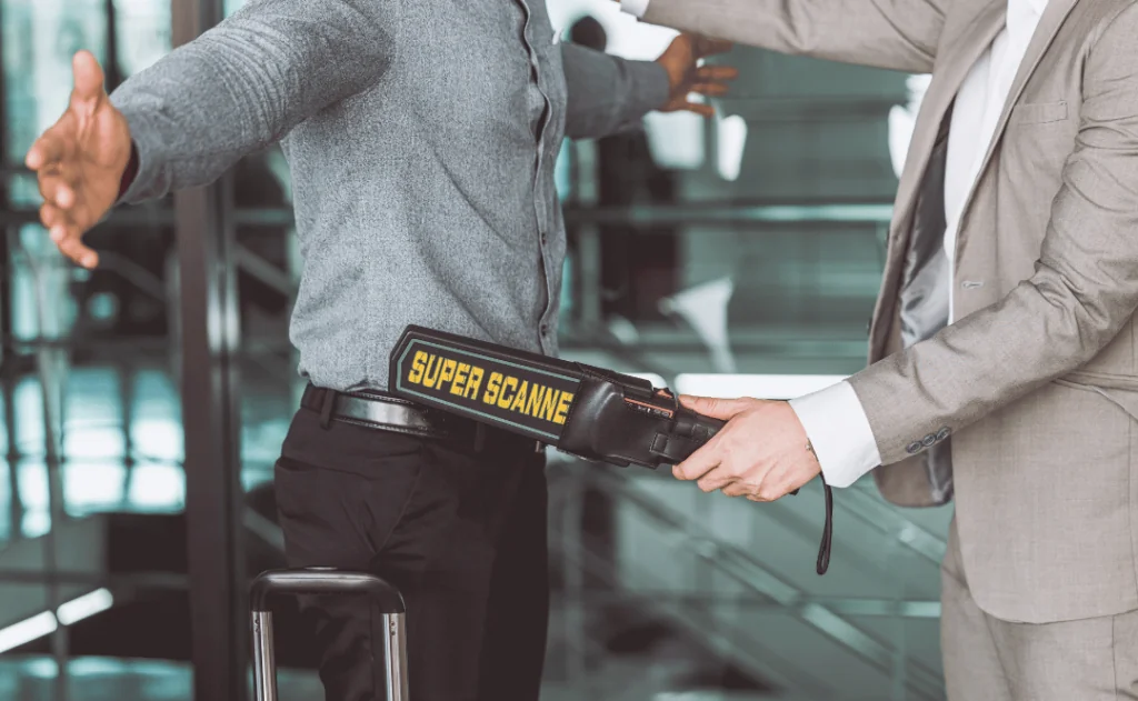 airport security check officer using metal weapon scanner detector check every passenger