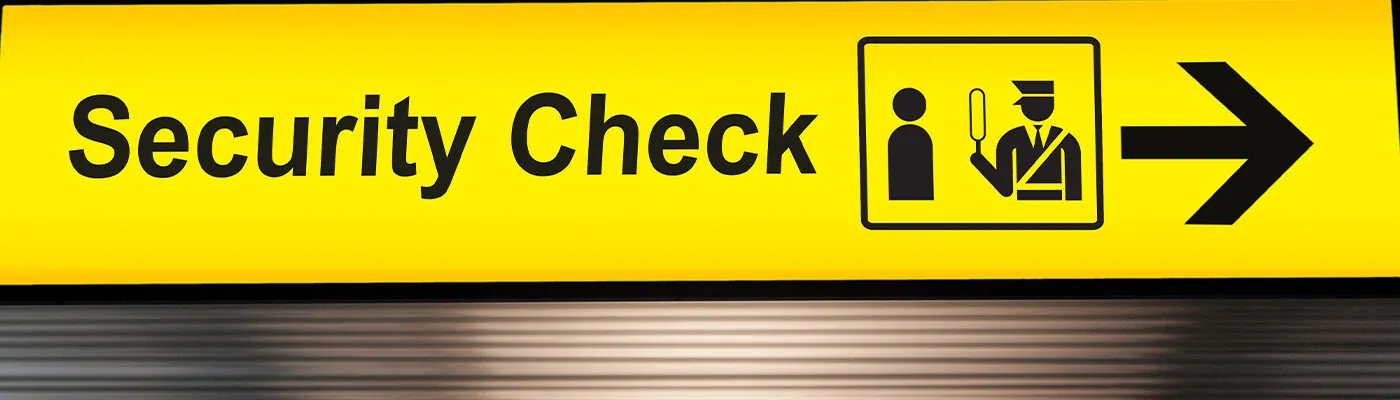 security check sign hanging from airport terminal ceiling